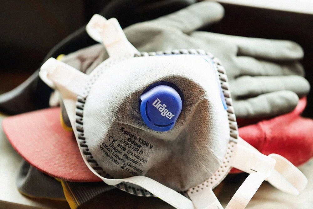Dust masks, a respirator and work gloves laid out together